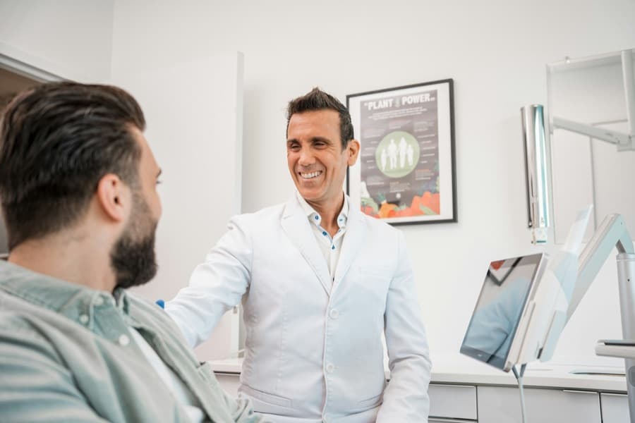 A dentist smiling with a patient in the chair